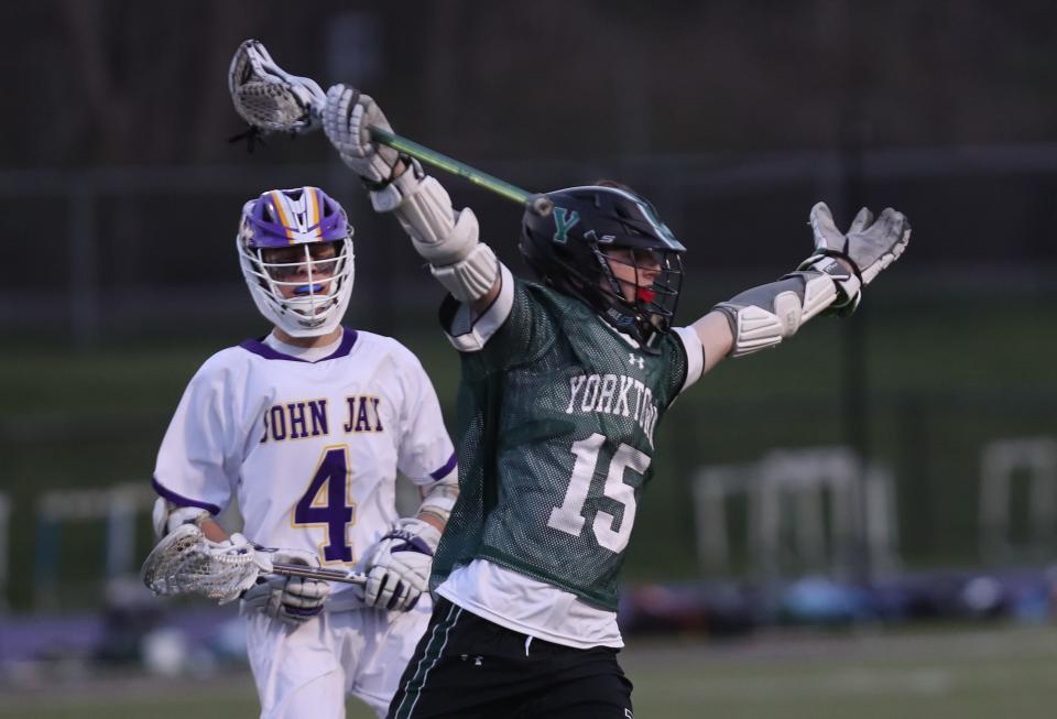 From right, Yorktown's Jack Duncan (15) celebrates a first half goal in front of John Jay's Ben Gold (4) during boys lacrosse action at John Jay High School in Cross River April 14, 2023. Yorktown won the game 9-8.