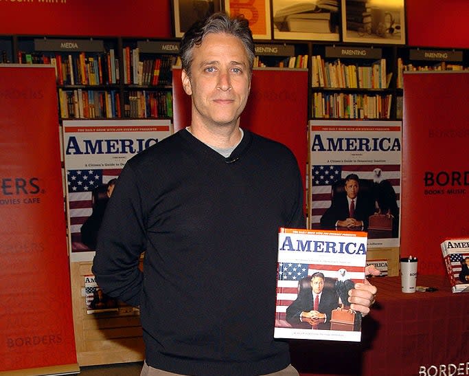 Jon Stewart holding his book