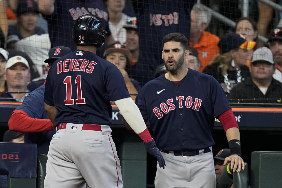 Boston Red Sox's Rafael Devers celebrates after a grand slam home run with J.D. Martinez against the Houston Astros during the second inning in Game 2 of baseball's American League Championship Series Saturday, Oct. 16, 2021, in Houston. (AP Photo/David J. Phillip)