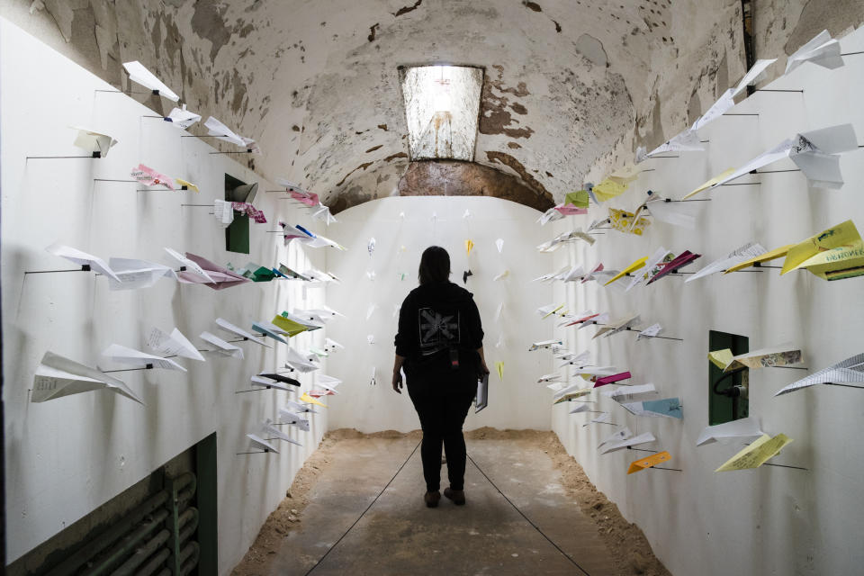A person views Benjamin Wills' installation titled Airplanes, Thursday, May 2, 2019, at the Eastern State Penitentiary, which is now a museum in Philadelphia. The paper airplanes were sent to Wills from his correspondence with incarcerated people. (AP Photo/Matt Rourke)