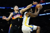 Golden State Warriors forward Andrew Wiggins shoots as Phoenix Suns guard Devin Booker (1) defends during the first half of an NBA basketball game, Tuesday, Nov. 30, 2021, in Phoenix. (AP Photo/Matt York)