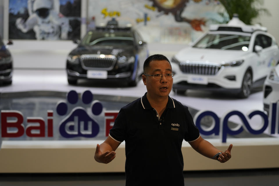 Wei Dong, vice president of Baidu's Intelligent Driving Group, speaks near a display showing the various prototypes of the self-driving taxi developed by tech giant Baidu Inc. on June 14, 2022, in Beijing. Baidu Inc. is China's highest-profile competitor in a multibillion-dollar race with Alphabet Inc.'s Waymo and General Motors Co.'s Cruise to create self-driving cars. (AP Photo/Ng Han Guan)