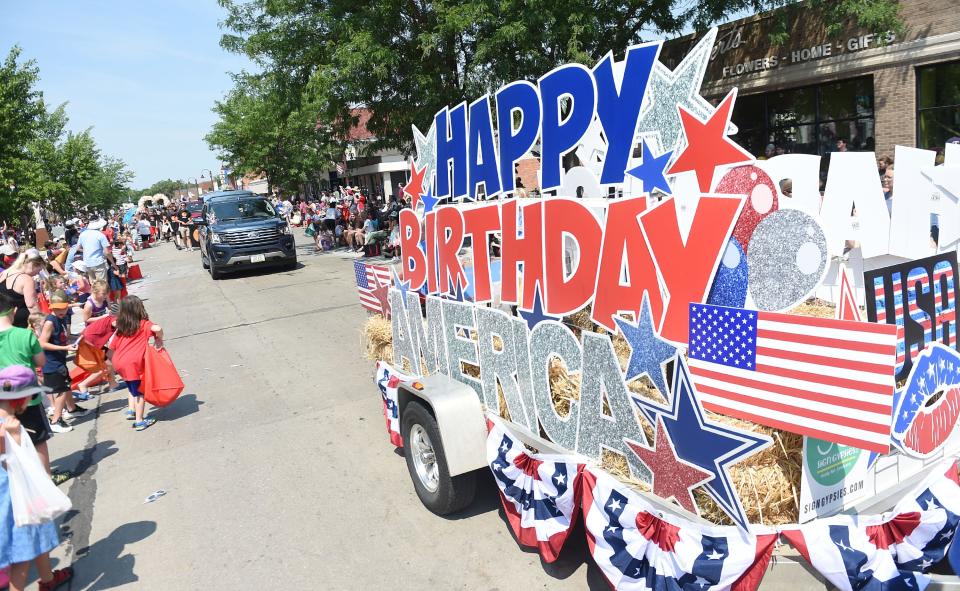 A "Happy Birthday America" sign passes by during Ames' Fourth of July parade on Main Street Sunday, July 4, 2021, in Ames, Iowa.