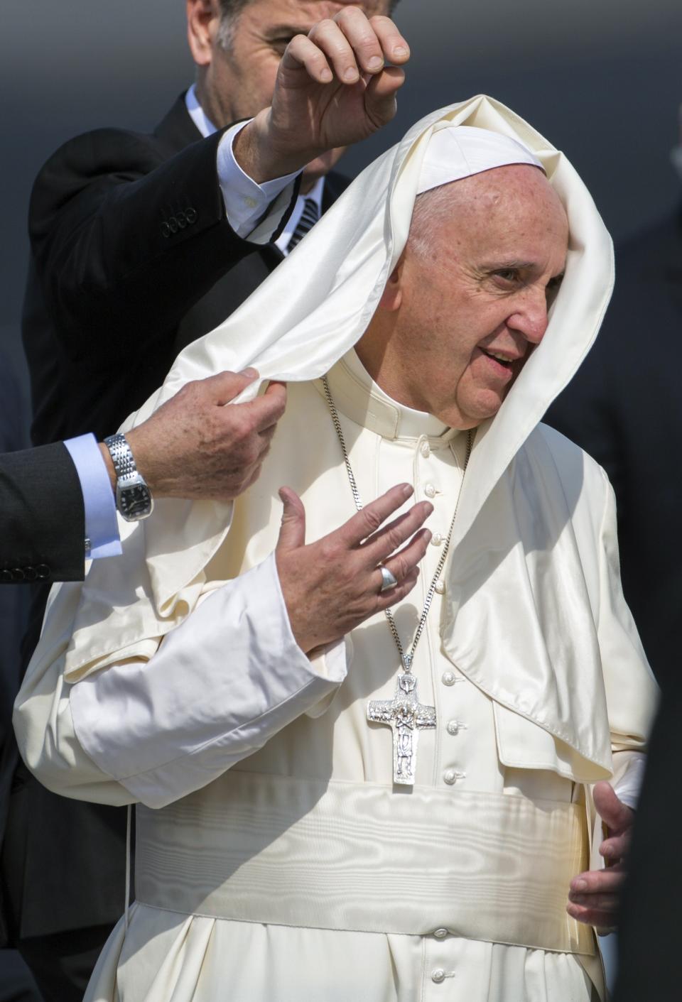 FILE - In this Feb. 12, 2016 file photo, wind blows part of Pope Francis' dress over his head as he arrives to Jose Marti Airport in Havana, Cuba. Pope Francis made a brief stop en route to Mexico. (AP Photo/Desmond Boylan, File)