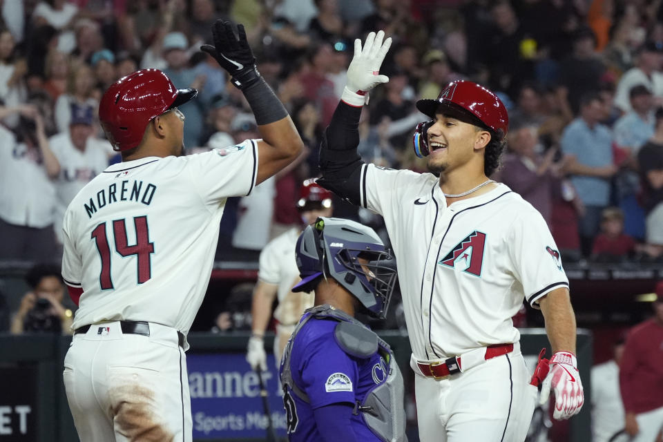 Arizona Diamondbacks' Alek Thomas, right, celebrates his three-run home run against the Colorado Rockies with Diamondbacks' Gabriel Moreno (14) during the sixth inning of a baseball game Friday, March 29, 2024, in Phoenix. (AP Photo/Ross D. Franklin)