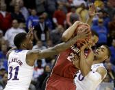 Kansas's Jamari Traylor (31) and Frank Mason (0) try to steal the ball from Stanford's Anthony Brown during the second half of a third-round game at the NCAA college basketball tournament Sunday, March 23, 2014, in St. Louis. Stanford won the game 60-57. (AP Photo/Charlie Riedel)