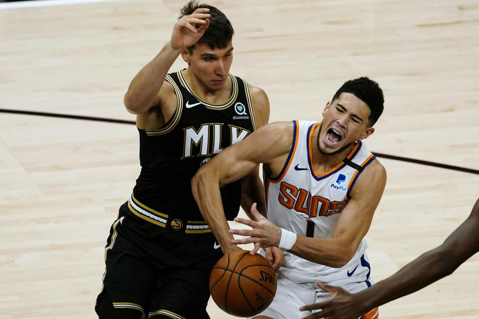 Phoenix Suns guard Devin Booker (1) is fouled by Atlanta Hawks forward Danilo Gallinari (8) in the first half of an NBA basketball game Wednesday, May 5, 2021, in Atlanta. (AP Photo/John Bazemore)