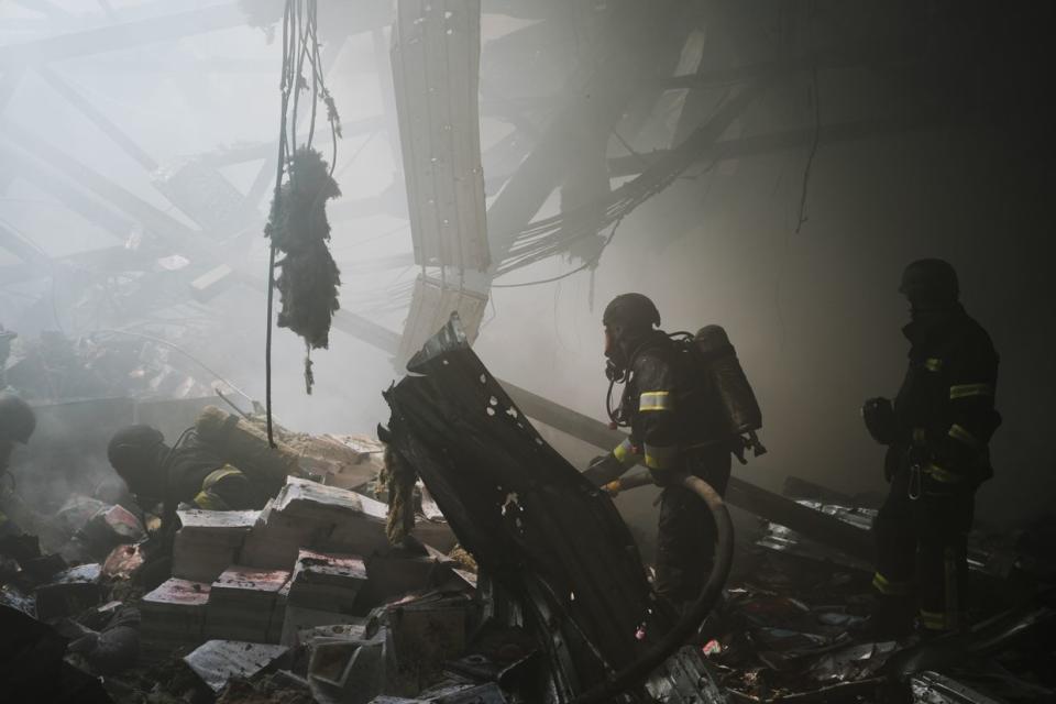 Ukrainian first responders work at the site of a Russian missile attack on a publishing factory in Kharkiv, Ukraine on May 23, 2024. (Francis Farrell/The Kyiv Independent)