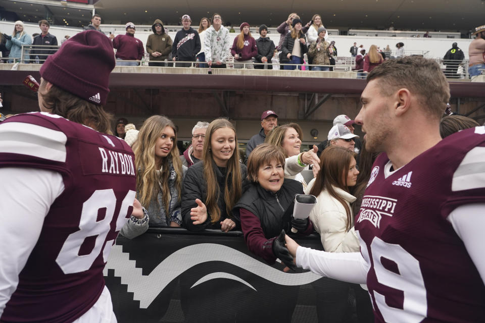 Mississippi State placekicker Massimo Biscardi, right, reaches out to receive congratulatory handshakes from attendees in the Mississippi State Gridiron Club after Mississippi State's win in an NCAA college football game against East Tennessee State, Saturday, Nov. 19, 2022, in Starkville, Miss. The end zones are not necessarily where you will find the cheap seats anymore at college football games. Several colleges have tried making end-zone seating more attractive by turning it into a premium experience that includes such amenities as access to indoor clubs with expanded food and beverage options. (AP Photo/Rogelio V. Solis)