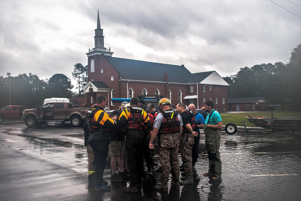 Rescue crews from Robeson County and the Cajun Navy go over maps in the parking lot of the Sandy Grove Baptist Church before launching their boats into a neighborhood on the south side of Lumberton on Sunday.