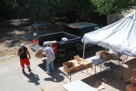 Volunteers load food donations into the truck of Gerald Ortiz Thursday, Sept. 23, 2021, in Chimayó, New Mexico. Ortiz said he regretted buying the truck a few months before the pandemic, and getting laid off from the company where he worked for 20 years. Half of Ortiz' unemployment, about $600 per month, has gone to his truck payments. To pay his bills he's cut back to eating only one meal per day.(AP Photo/Cedar Attanasio)