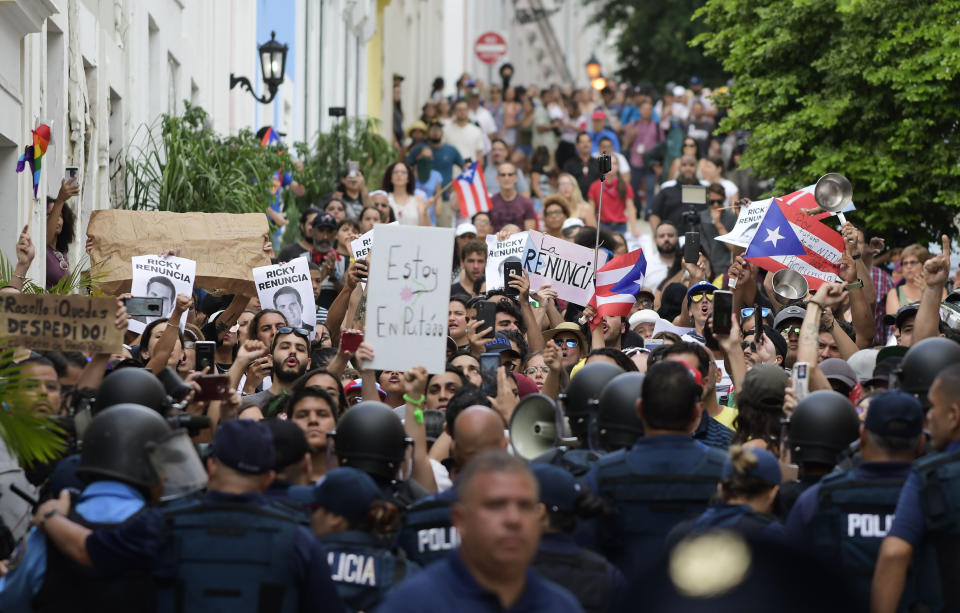 Police block protesters from advancing to La Fortaleza governor's residence in San Juan, Puerto Rico, Sunday, July 14, 2019. Protesters are demanding Gov. Ricardo Rosselló step down for his involvement in a private chat in which he used profanities to describe an ex-New York City councilwoman and a federal control board overseeing the island's finance. (AP Photo/Carlos Giusti)