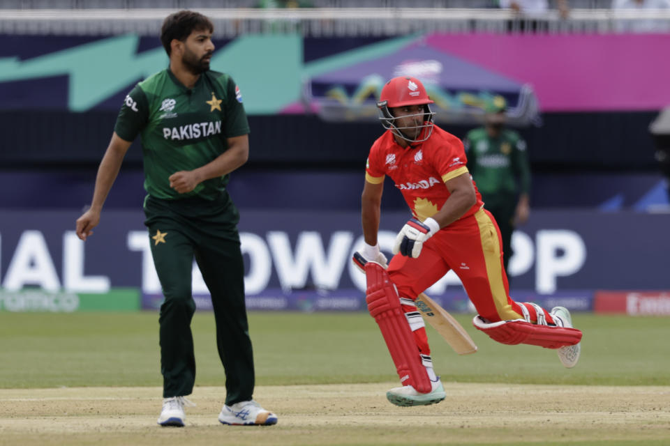 Canada's captain Saad Bin Zafar, right, runs past Pakistan's Haris Rauf after playing a shot during the ICC Men's T20 World Cup cricket match between Pakistan and Canada at the Nassau County International Cricket Stadium in Westbury, New York, Tuesday, June 11, 2024. (AP Photo/Adam Hunger)