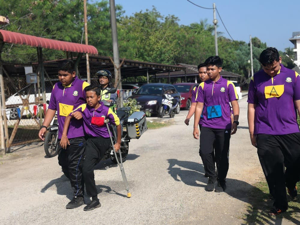 Haikal, aided by his friend, walks along the course during SMK Muadzam Shah’s annual school road run.—Picture via Facebook/SMK Muadzam Shah The Official