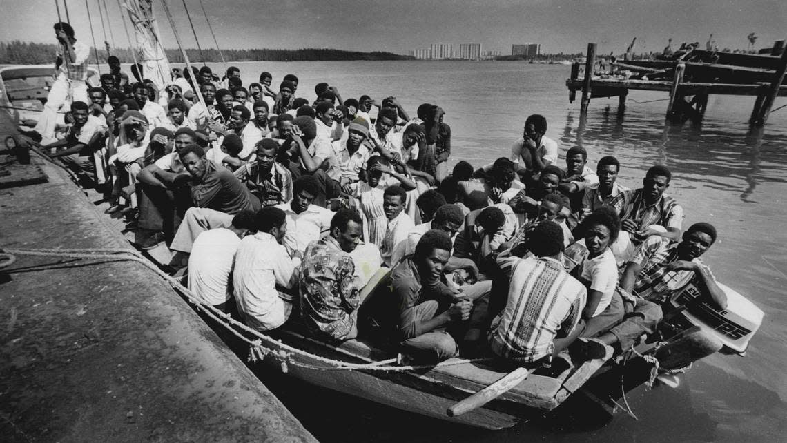 About 100 Haitians aboard a boat with a 25 horsepower Evinrude motor land at Haulover Beach Marina.