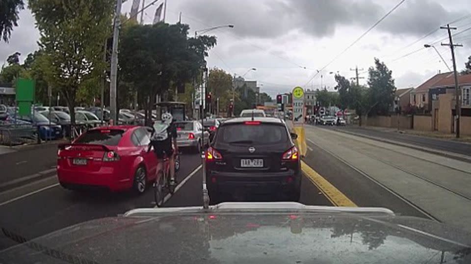 The cyclist makes his way in between the two lanes unaware of the pedestrian's location. Source: 7 News