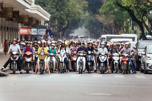 Crowd of motorcycles wait at traffic light in Hanoi, Vietnam