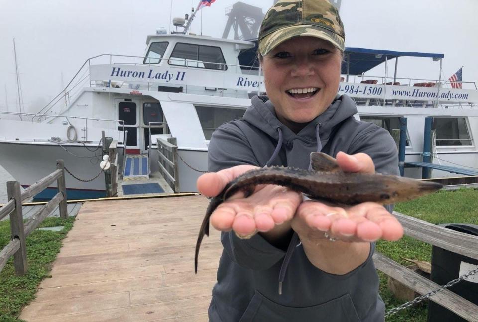 Former Huron Lady II owner Jenny Ciolek holds up a sturgeon during a past Port Huron event with the sightseeing vessel behind her.