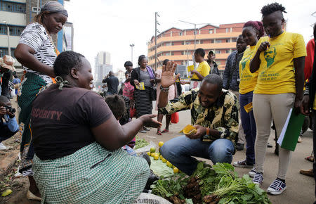 Kenyan social-political activist Boniface Mwangi (C) talks to a street hawker during his political campaign ahead of the August elections along the streets of downtown Nairobi, Kenya, May 31, 2017. Picture taken May 31, 2017. REUTERS/Thomas Mukoya