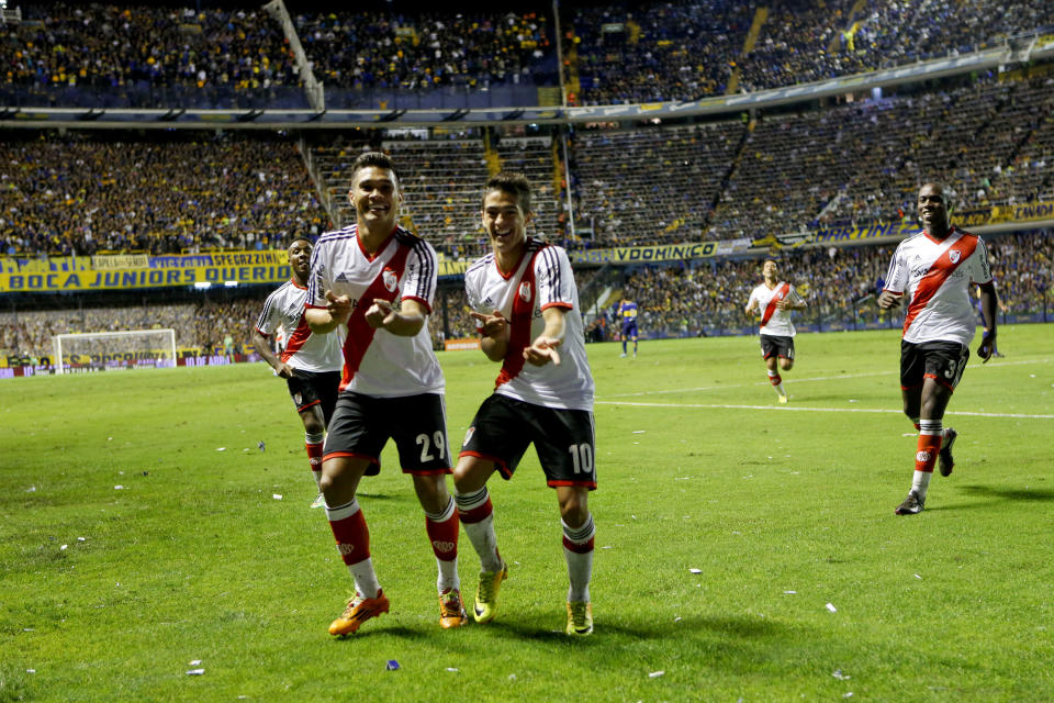 River Plate's Manuel Lanzini, center right, celebrates with teammate Teofilo Gutierrez, left, after scoring against Boca Juniors during an Argentine league soccer match in Buenos Aires, Argentina, Sunday, March 30, 2014. (AP Photo/Victor R. Caivano)