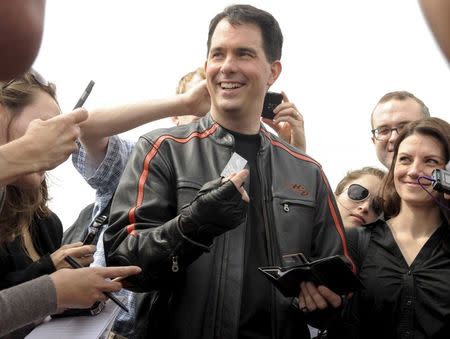 Wisconsin Governor Scott Walker shows off his motorcycle driver's license before a "Roast & Ride" fund-raising event sponsored by Senator Joni Ernst (R-IA) in Des Moines, Iowa in this June 6, 2015 file photo. REUTERS/Dave Kaup/Files