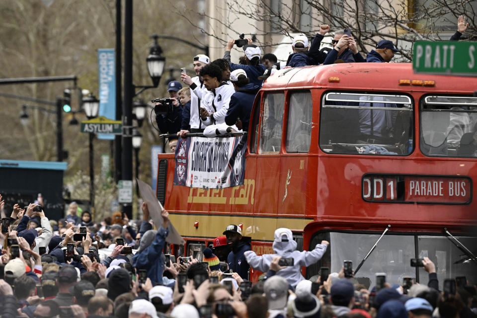 Fans surround a double-decker bus carrying the UConn men's basketball team during a parade to celebrate the team's NCAA college basketball championship, Saturday, April 13, 2024, in Hartford, Conn. (AP Photo/Jessica Hill)