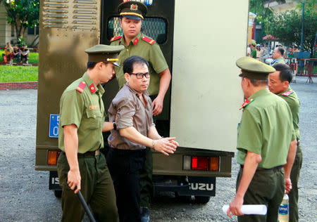 U.S. citizen James Nguyen (C) is escorted by police to a court before his trial in Ho Chi Minh city, Vietnam August 21, 2018. REUTERS/Stringer NO RESALES. NO ARCHIVES