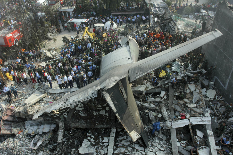 FILE - In this Tuesday, June 30, 2015 file photo, rescuers search for victims at the site where an Hercules C-130 air force cargo plane crashed into a residential neighborhood in Medan, North Sumatra, Indonesia. On Friday, March 15, 2018, The Associated Press has found that a similar photo from the Reuters news agency circulating on the internet was falsely identified as the Ethiopian Airlines Boeing 737 Max 8 jet that crashed on Sunday, March 10, 2019. (AP Photo/Yudha Lesmana)