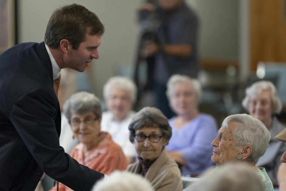 FILE - In this Thursday, Sept. 27, 2019 file photo, Kentucky Attorney General and Democratic gubernatorial candidate Andy Beshear greets residents at Sayre Christina Village Senior Living Center in Lexington, Ky. While Democrats in Washington charge ahead with an impeachment inquiry, their party’s candidates for governor in three Southern states are doing their best to steer the conversation away from Republican President Donald Trump and toward safer ground back home. (AP Photo/Bryan Woolston, File)