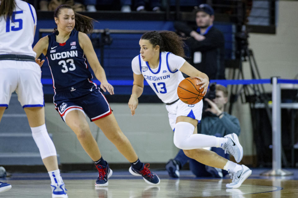 Creighton's Rachael Saunders (13) drives against against UConn's Caroline Ducharme (33) during the first half of an NCAA college basketball game Wednesday, Dec. 28, 2022, in Omaha, Neb. (AP Photo/John Peterson)