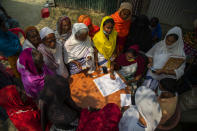 Elderly women wait to register for a COVID-19 vaccine in Bahakajari village in an interior part of Indian northeastern state of Assam, India, Tuesday, March 23, 2021. In India, workers recently trekked to the tiny village to start vaccinating its nearly 9,000 residents. (AP Photo/Anupam Nath)