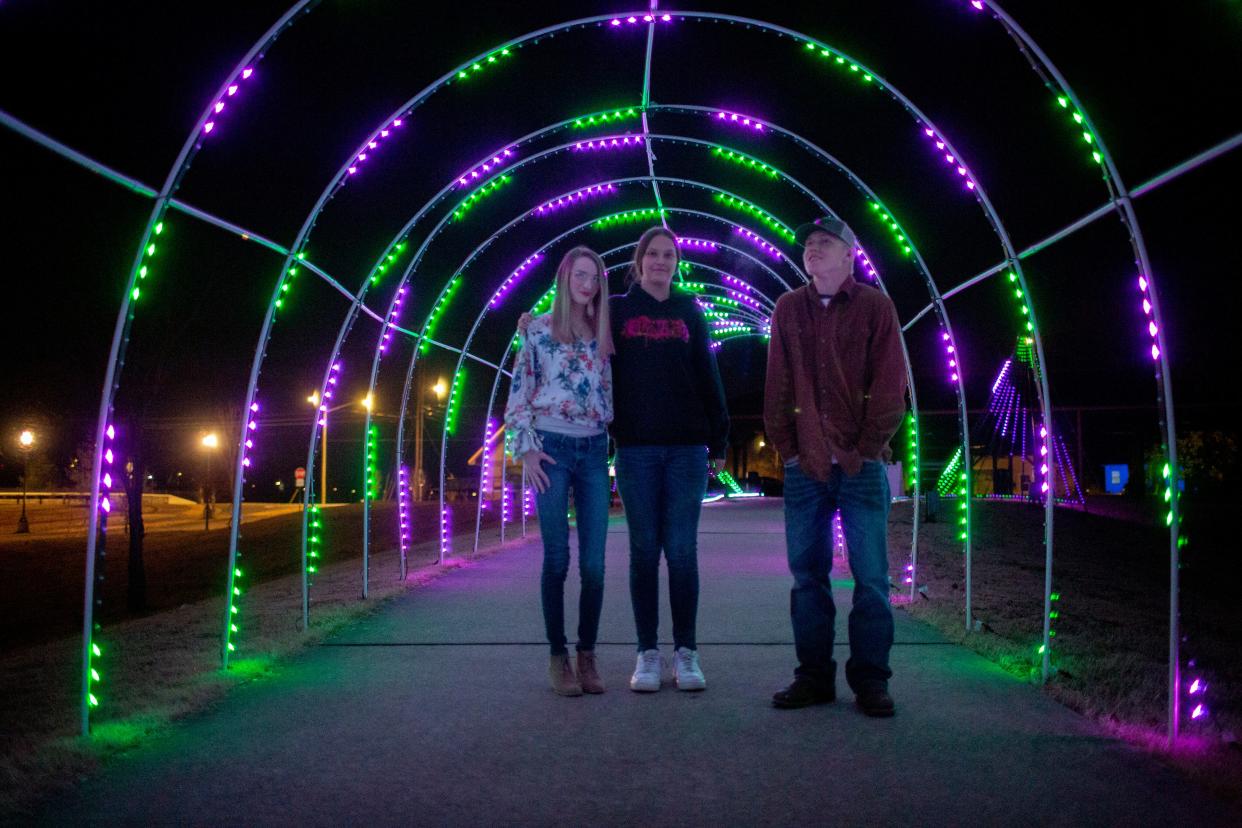 Elizabeth Wright, Kayli Vazanko and Evan Gore visit a holiday light exhibition at Riverwalk Park in Columbia, Tenn., on Monday, Dec. 13, 2021.