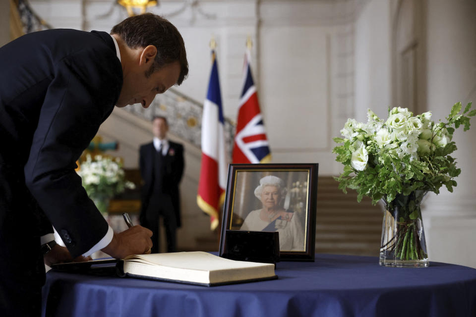 El presidente francés Emmanuel Macron firma un libro de condolencias tras la muerte de la reina Isabel de Gran Bretaña en la embajada británica en París, Francia, el 9 de septiembre de 2022. La reina Isabel II, la monarca con el reinado más largo de Gran Bretaña y una roca de estabilidad en buena parte de un siglo turbulento, falleció el jueves 8 de septiembre de 2022 tras 70 años en el trono. Tenía 96 años. (Christian Hartmann/Pool via AP)