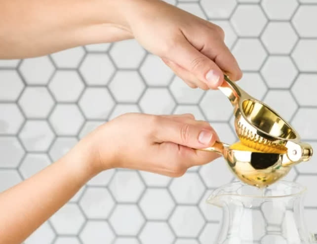 model using gold-tone juicer to squeeze juice out of lemon