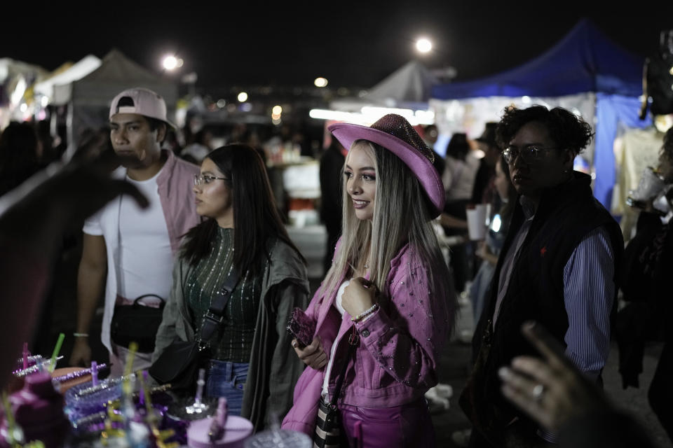 Una fan de Karol G compra mercancía previo a un concierto de su gira "Mañana será bonito" en el Estadio Azteca de la Ciudad de México el jueves 8 de febrero de 2024. (Foto AP/Eduardo Verdugo)