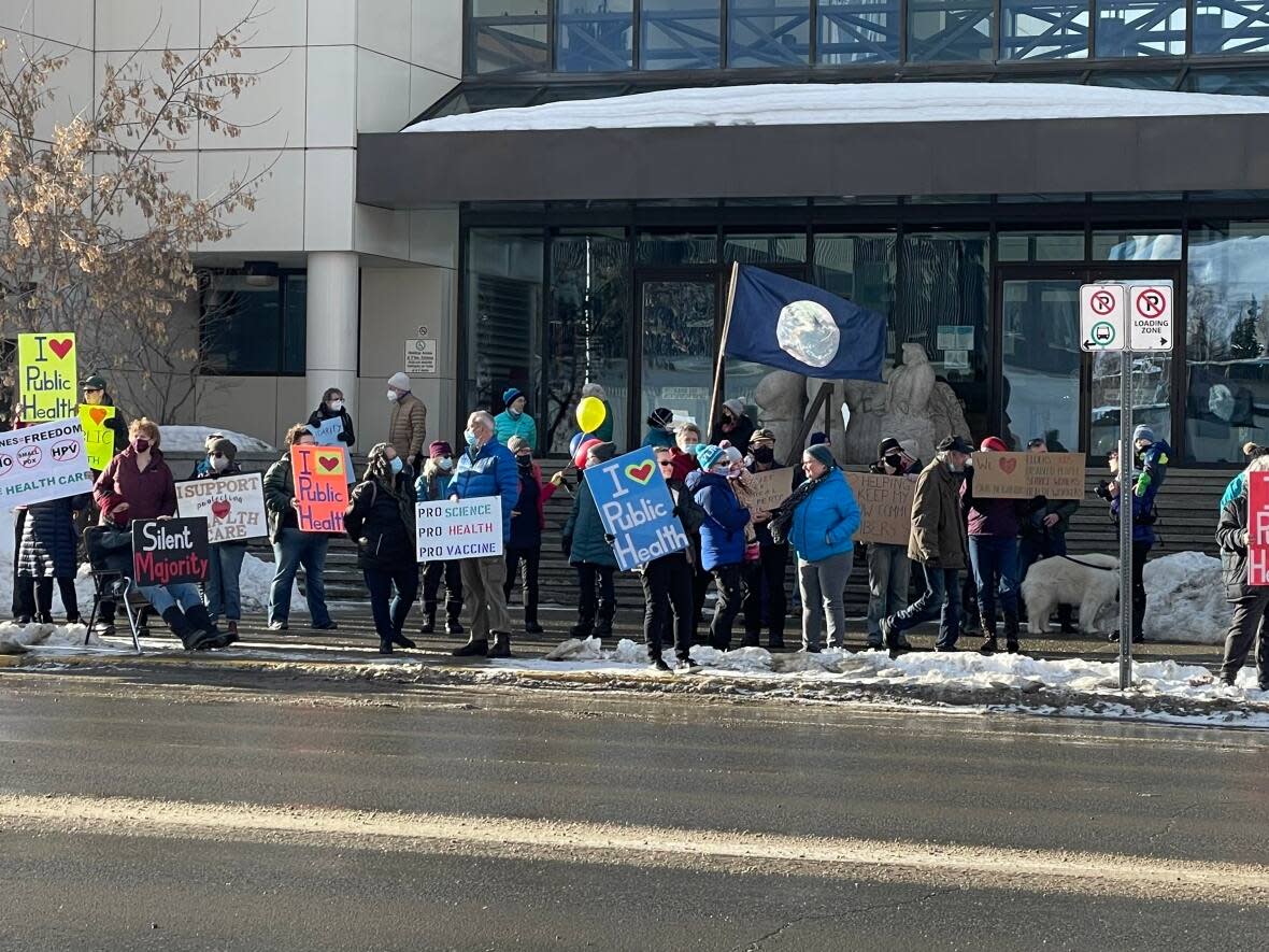 Over 60 people stood outside of the Supreme Court of Yukon building on Saturday, Feb. 12, 2022 to show their support for public health care workers. (Sissi De Flaviis/CBC - image credit)