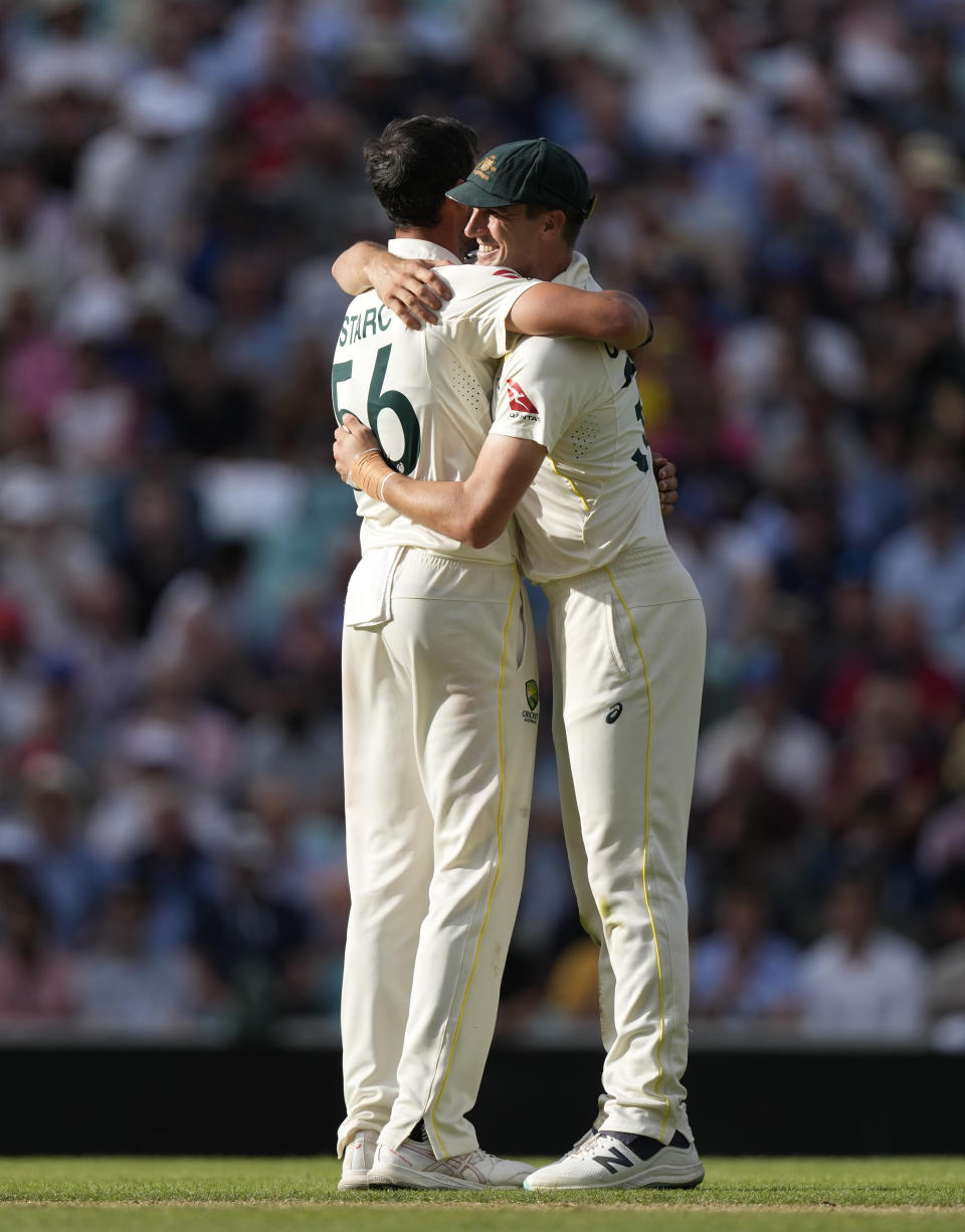 Australia's Mitchell Starc, left, with Australia's Pat Cummins, right, celebrate the dismissal of England's Moeen Ali on day three of the fifth Ashes Test match between England and Australia, at The Oval cricket ground in London, Saturday, July 29, 2023. (AP Photo/Kirsty Wigglesworth)