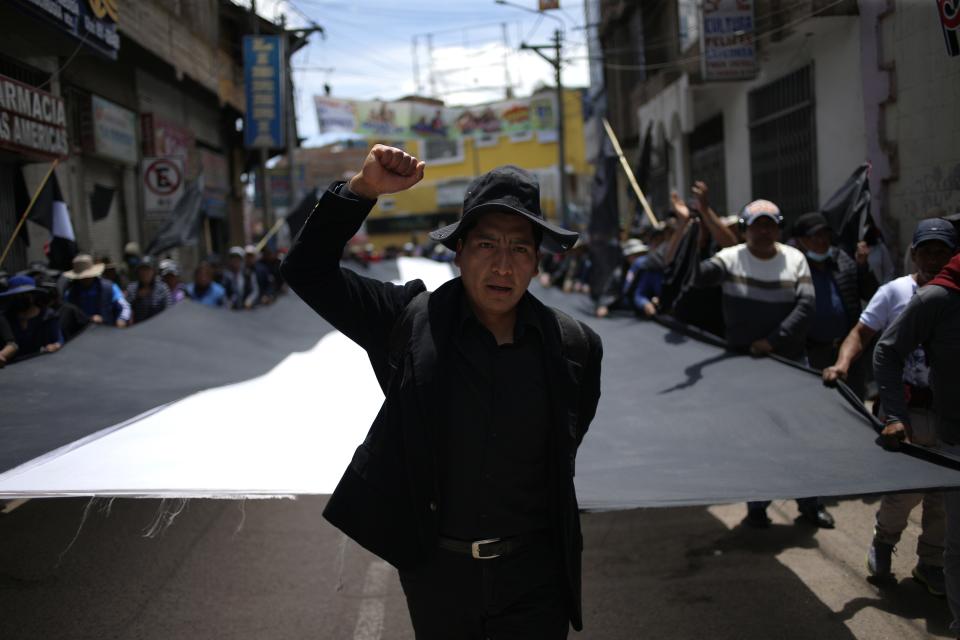 Manifestantes con una bandera peruana en blanco y negro, durante la marcha fúnebre por los fallecidos durante los disturbios en Juliaca, Perú, el 11 de enero de 2023. Al menos 17 personas fallecieron el lunes en el sureste de Perú en la reanudación de las protestas que reclaman elecciones en zonas rurales que siguen siendo leales al depuesto presidente Pedro Castillo. (AP Foto/Hugo Curotto)