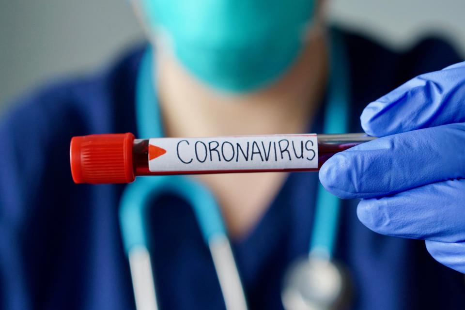 Nurse wearing respirator mask holding a positive blood test result for the new rapidly spreading Coronavirus, originating in Wuhan, China