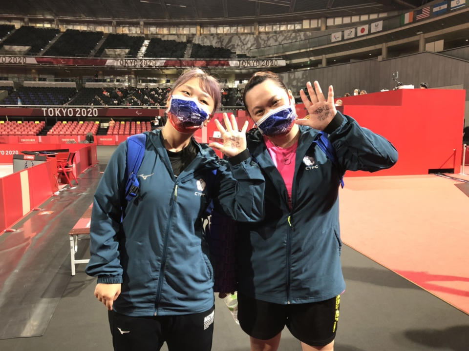台灣桌球女將田曉雯（左）28日在東京帕拉林匹克運動會桌球第10級女單8強賽逆轉勝，成功挺進4強。圖為田曉雯和教練蔡貴蘭（右）在手上寫下加油打氣的話。（體育署提供）
