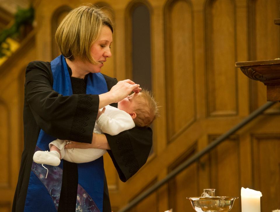 Nanette Pitt baptizes a child at First Congregational Church in Akron.