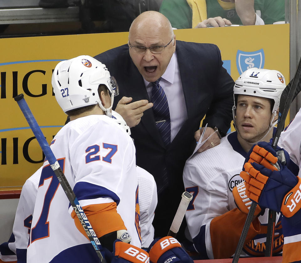 New York Islanders head coach Barry Trotz, center, gives instructions to Anders Lee (27) during the third period in Game 3 of an NHL first-round hockey playoff series against the Pittsburgh Penguins in Pittsburgh, Sunday, April 14, 2019. The Islanders won 4-1. (AP Photo/Gene J. Puskar)