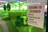 A sign at a Whole Foods in Lake Oswego, Ore., advises that the store is closed due to poor air quality Monday, Sept. 14, 2020. Another sign said all Whole Foods stores in the Portland Metro area will be closed at least through Thursday due to air quality. People across the West struggled under acrid-yellowish green smog from raging wildfires that seeped into homes and businesses, sneaked into cars through air conditioning vents and caused the temporary closure of iconic locations such as Powell's Books and the Oregon Zoo. And forecasters say the putrid air, measured as the worst on the planet, could last well into the week. (AP Photo/Gillian Flaccus)