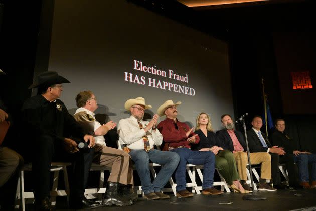 Sheriffs and panelists are seen on stage as the screen reads 