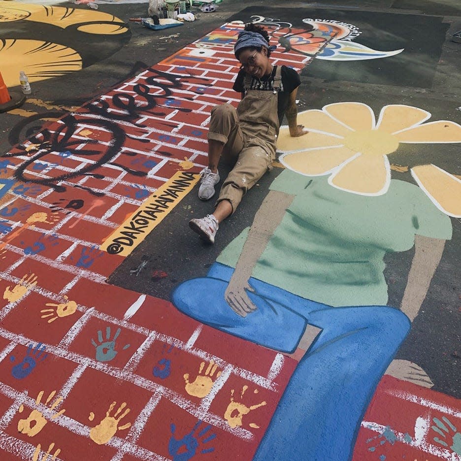 Dakotah Aiyanna poses with her letter L from the BLACK LIVES MATTER street mural in Charlotte.