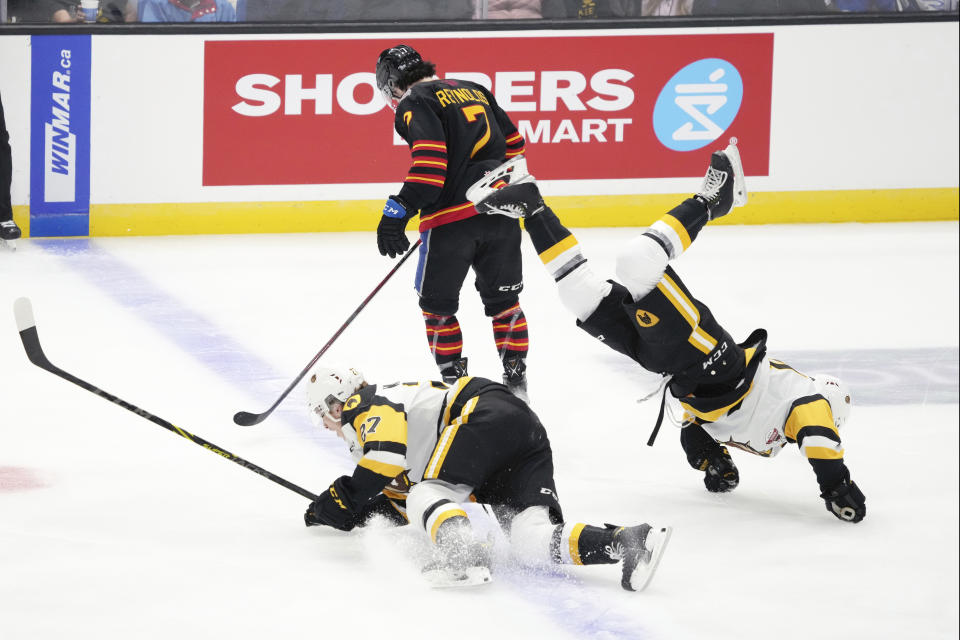 Hamilton Bulldogs' Ryan Winterton, left, and teammate Nathan Staios, right, collide in front of Saint John Sea Dogs' Peter Reynolds during the first period of a Memorial Cup hockey game in Saint John, Canada, on Monday, June 20, 2022. (Darren Calabrese/The Canadian Press via AP)
