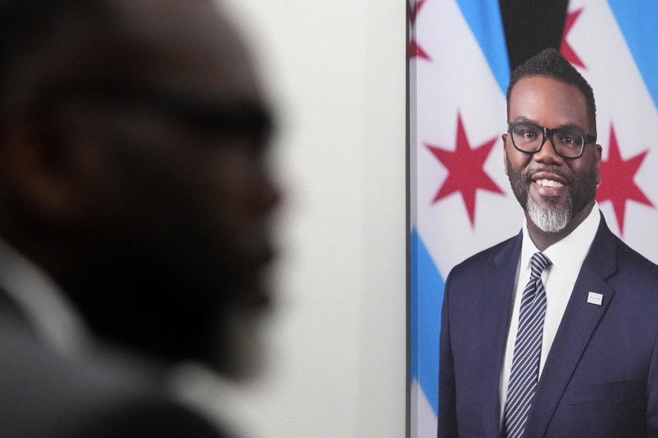 With his official portrait hanging on the wall, Chicago Mayor Brandon Johnson responds to a question in his City Hall office during an interview with The Associated Press Monday, May 6, 2024, in Chicago. The rookie mayor's bumpy first year has been a test of his progressive credentials. He's navigated an evolving migrant crisis, budget gaps, persistent crime and a troubled transit system to name a few. While there have been wins for workers and social services, he's struggled with businesses, police and fellow Democrats. (AP Photo/Charles Rex Arbogast)