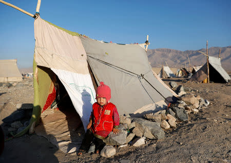 An internally displaced Afghan child sits outside a tent at a refugee camp in Herat province, Afghanistan October 14, 2018. Picture taken October 14, 2018. REUTERS/Mohammad Ismail