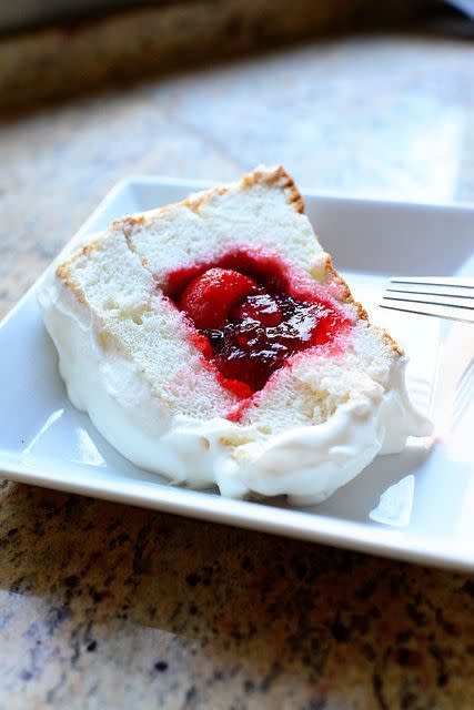 strawberry sparkle cake filled with strawberries on white plate