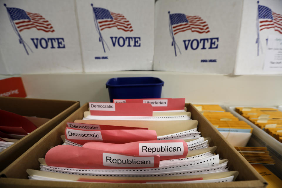 In this April 14, 2020 photo, ballots for the primary elections are arranged by party affiliation at the Lancaster County Election Committee offices in Lincoln, Neb. Officials in Nebraska are forging ahead with plans for the state’s May 12 primary despite calls from Democrats to only offer voting by mail and concerns from public health officials that in-person voting will help the coronavirus spread. Republican leaders have encouraged people to request absentee ballots but say polling places will be open. (AP Photo/Nati Harnik)